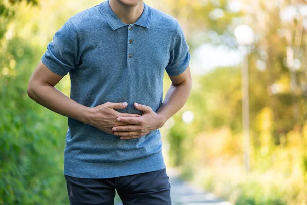 屋外で歩くときの腹痛 自然の背景に胃の痛みを持つ男 健康上の問題の概念 — ストック写真