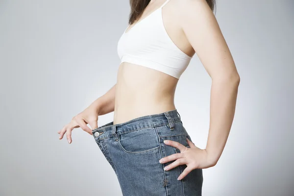 Mujer joven en jeans de gran tamaño, concepto de pérdida de peso —  Fotos de Stock