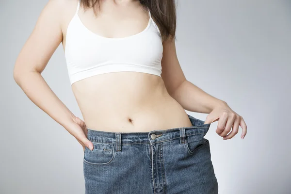 Jovem mulher em jeans de grande porte, conceito de perda de peso — Fotografia de Stock