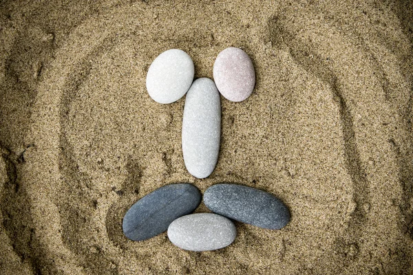 Smiley aus Steinen auf Sand Nahaufnahme — Stockfoto