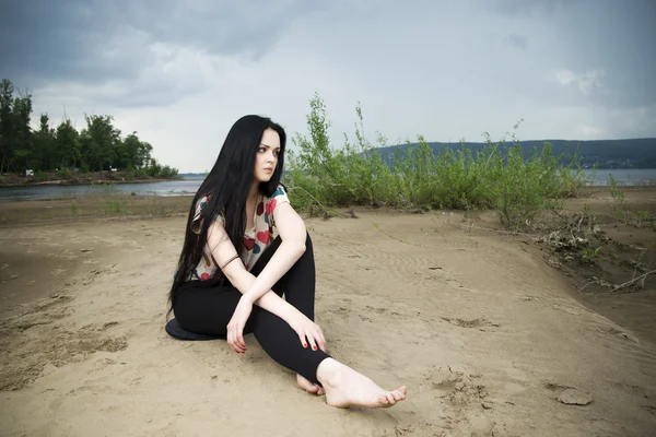 Beautiful young woman on a sandy beach — Stock Photo, Image