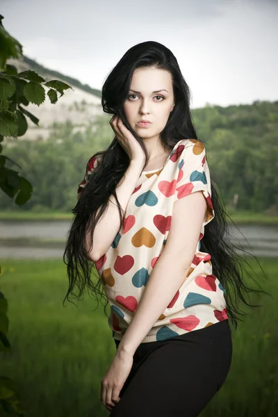 Portrait of a beautiful young woman on the background of the hill — Stock Photo, Image