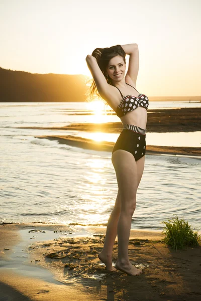 Piękna kobieta w bikini na tle zachodu słońca — Zdjęcie stockowe