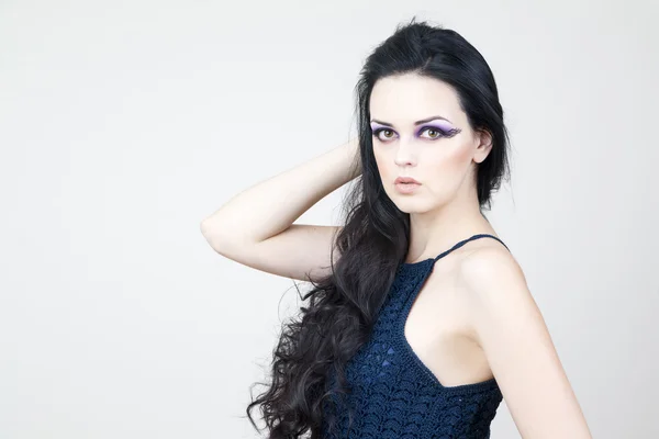 Portrait of a beautiful young woman on a gray background — Stock Photo, Image