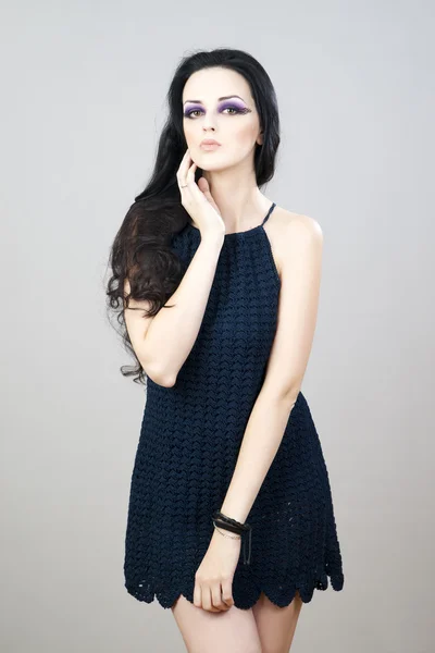 Portrait of a beautiful young woman on a gray background — Stock Photo, Image