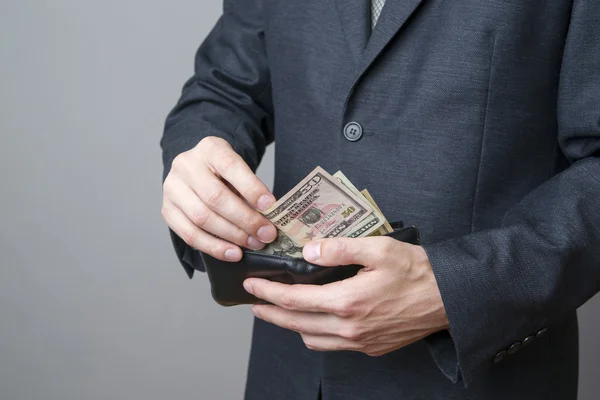 Empresario con dinero en cartera en las manos — Foto de Stock