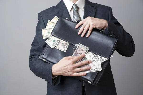 Businessman with a briefcase full of money in the hands of — Stock Photo, Image