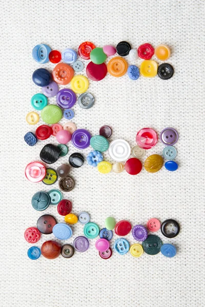 Lettre E de l'alphabet des boutons de différentes formes et couleurs — Photo