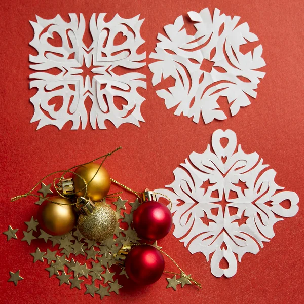 Christmas balls and snowflakes on a red background — Stock Photo, Image