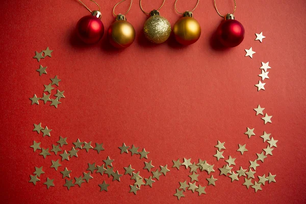 Christmas balls and stars on a red background — Stock Photo, Image