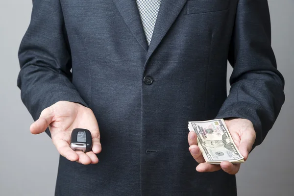 Businessman using car key and money — Stock Photo, Image