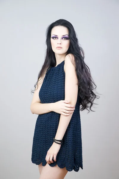 Portrait of a beautiful young woman on a gray background — Stock Photo, Image