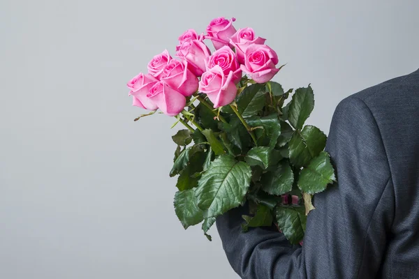 Homme en costume avec bouquet de roses roses — Photo