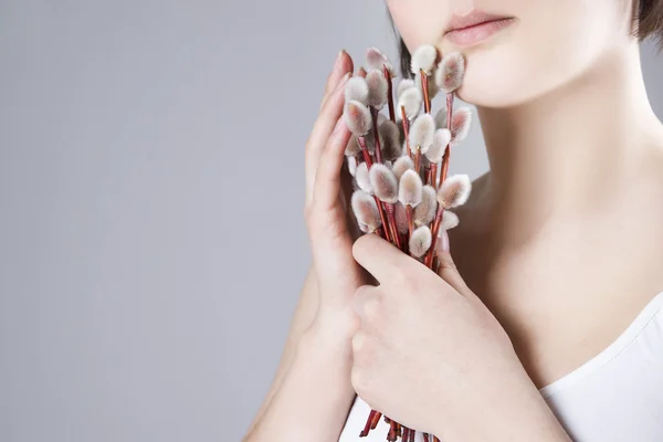 Femme avec branches de saule dans les mains sur un fond gris — Photo