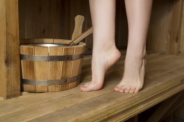 Beautiful female legs in sauna, bath accessories — Stock Photo, Image