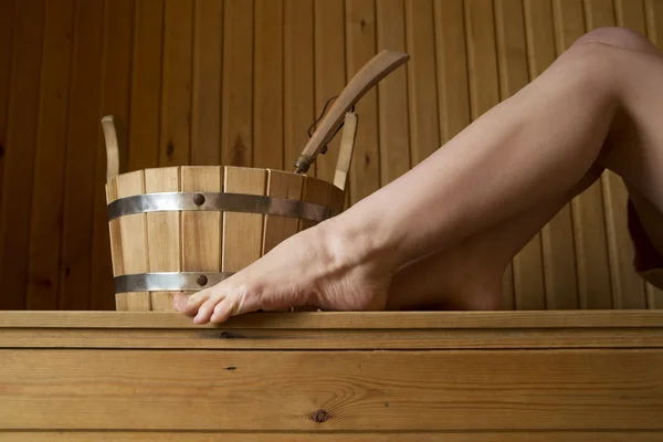 Beautiful female legs in sauna, bath accessories — Stock Photo, Image