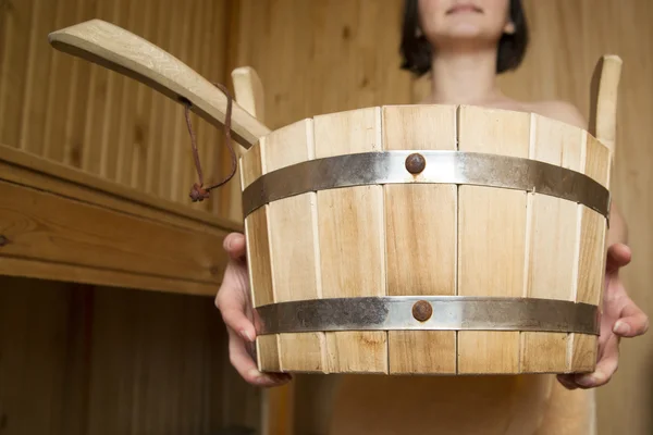 Balde nas mãos de mulheres na sauna, acessórios de banho — Fotografia de Stock