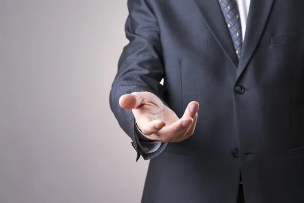 El hombre de traje extiende una mano vacía — Foto de Stock