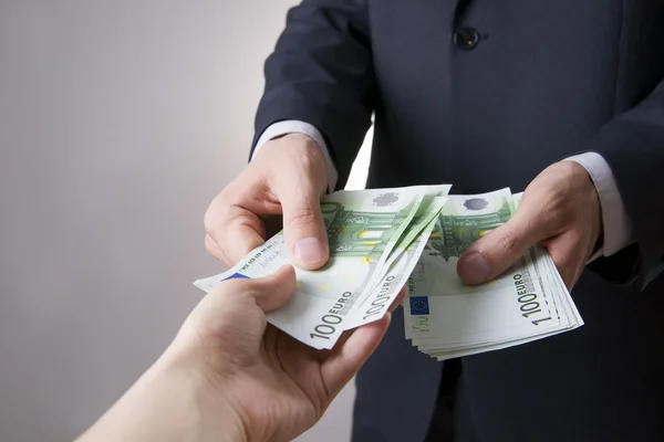 Geld in de handen van het volk — Stockfoto