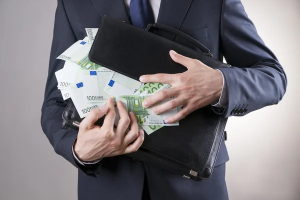 Üzletember-val a kezében a pénzzel teli táskát — Stock Fotó