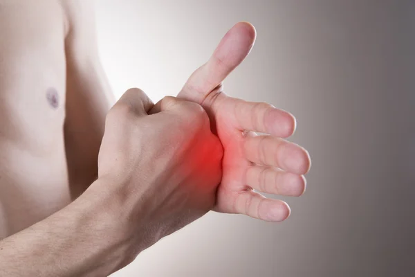 Pain in the hand on a gray background — Stock Photo, Image