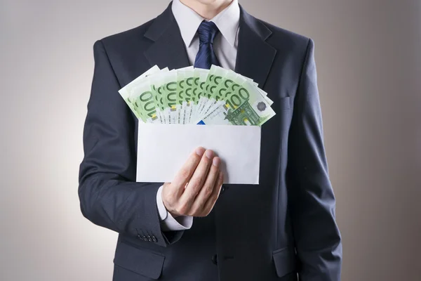 Деньги в конверте в руках мужчин Стоковое Фото