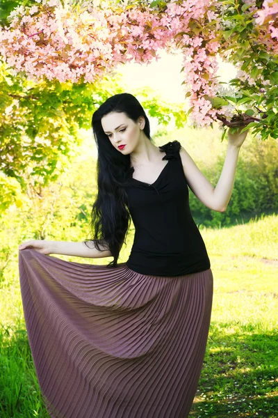 Hermosa mujer joven en jardines florecientes — Foto de Stock