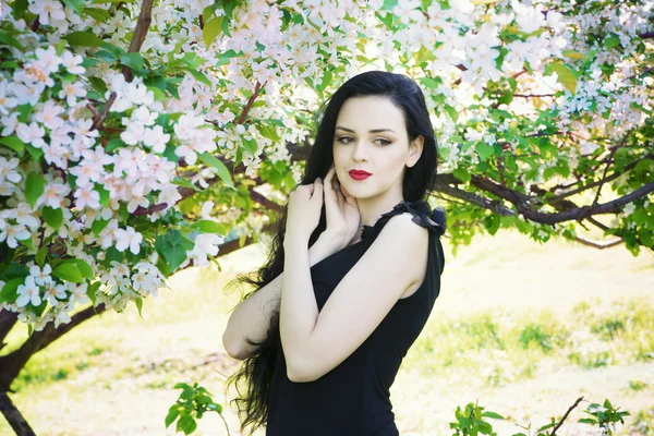 Schöne junge Frau in blühenden Gärten — Stockfoto