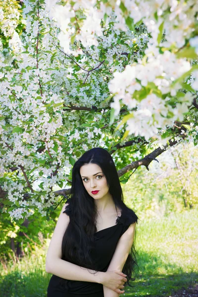 Hermosa mujer joven en jardines florecientes — Foto de Stock