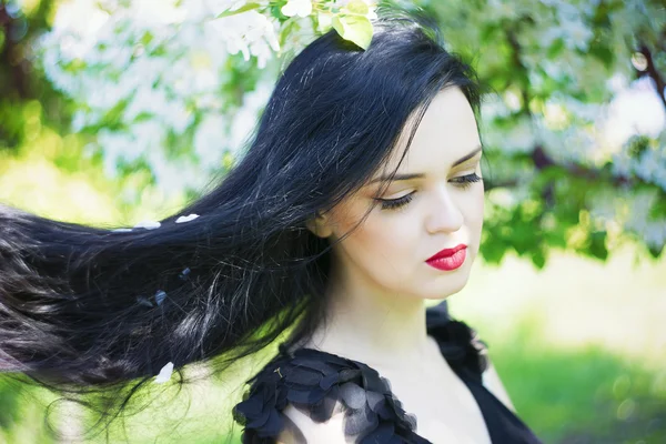 Beautiful young woman in blooming gardens — Stock Photo, Image