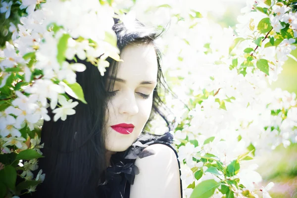 Hermosa mujer joven en jardines florecientes — Foto de Stock