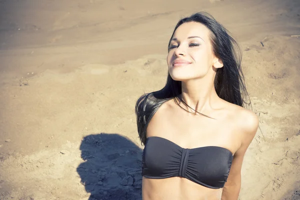 Sorrindo bela mulher tomando sol em uma praia — Fotografia de Stock