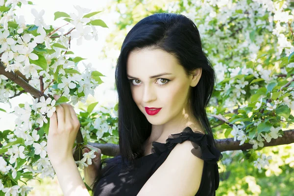 Beautiful young woman with flowers — Stock Photo, Image