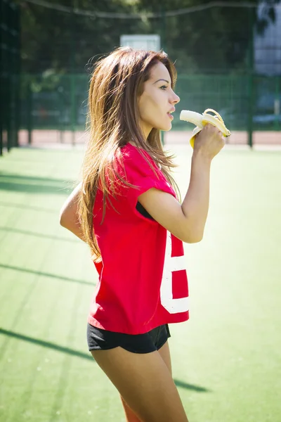 Feliz bela jovem comendo uma banana — Fotografia de Stock