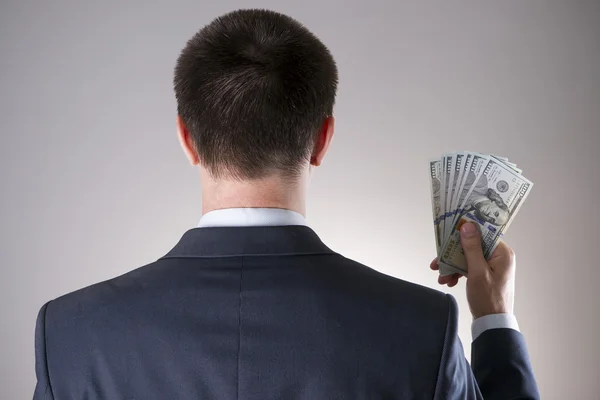 Бізнесмен з грошима в студії на сірому фоні — стокове фото