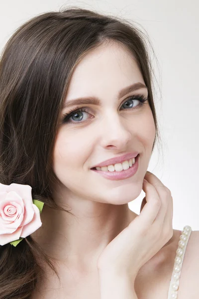 Studio portrait of a young beautiful bride. Professional make-up and hairstyle with flowers — Stock Photo, Image
