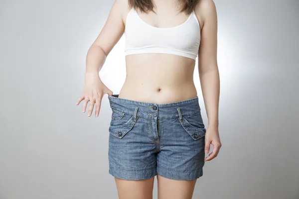 Jonge vrouw in jeans van grote omvang, concept van verlies van het gewicht — Stockfoto