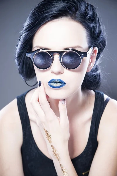 Портрет модели в солнцезащитных очках с синими губами и серьгами. Творческая прическа и макияж — стоковое фото