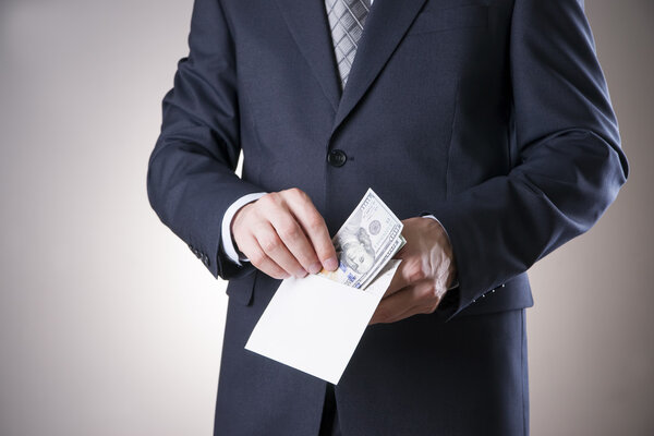 Бизнесмен с деньгами в студии. Концепция коррупции. Сто долларов
