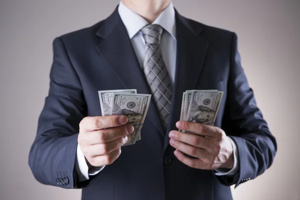 Uomo d'affari con soldi in studio. Concetto di corruzione. Banconote da cento dollari — Foto Stock
