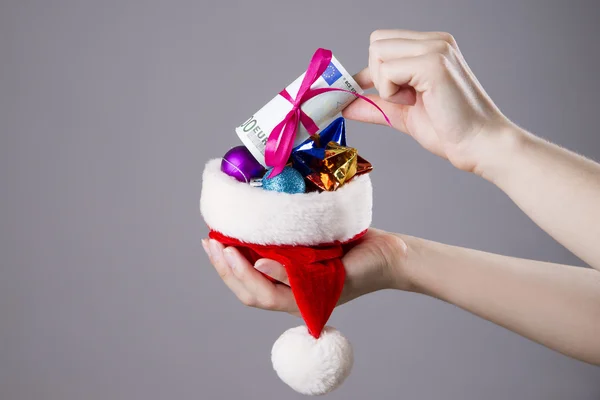 Cappello Babbo Natale con soldi nelle mani della donna — Foto Stock