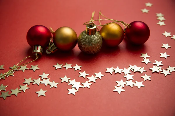 Christmas balls and stars on red background — Stock Photo, Image