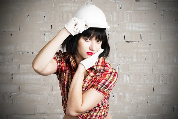 Hermosa joven sexy mujer en un casco blanco posando con equipo de construcción — Foto de Stock