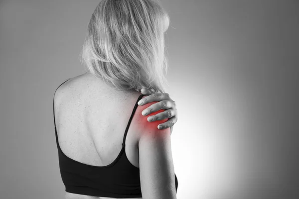 Žena s bolestí v rameni. Bolest v lidském těle na šedém pozadí — Stock fotografie