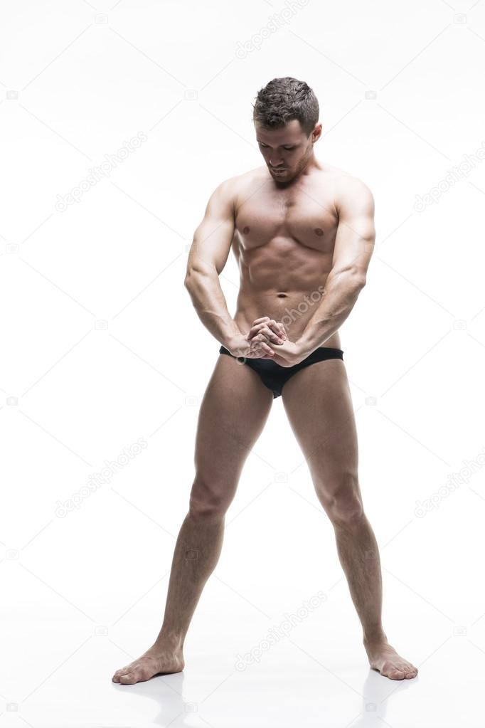 Handsome muscular bodybuilder posing on white background. Isolated studio shot