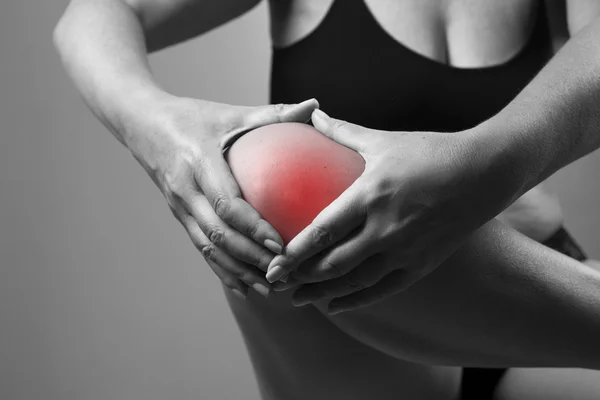 Біль у коліні. Біль у тілі людини на сірому фоні — стокове фото