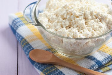 Süzme peynir ile bir tahta kaşık, yakın çekim, şartlarını bir cam