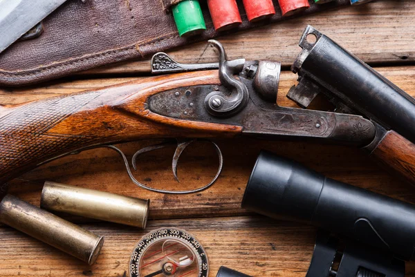 Lovecké pušky, kazeta pásek, dalekohled na dřevěný stůl — Stock fotografie