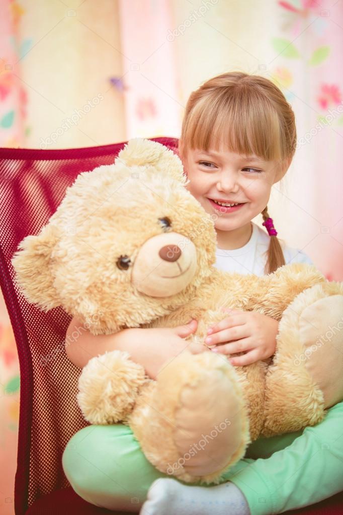 little girl hugging teddy bear