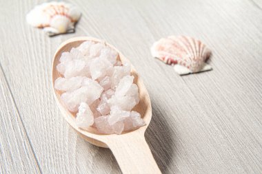 Banyo işlemleri için beyaz deniz tuzu ve tahta kaşık. Spa ürünleri ve aksesuarları